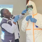 Health workers wearing protective equipment prepare an Ebola infection prevention area in the Democratic Republic of the Congo.