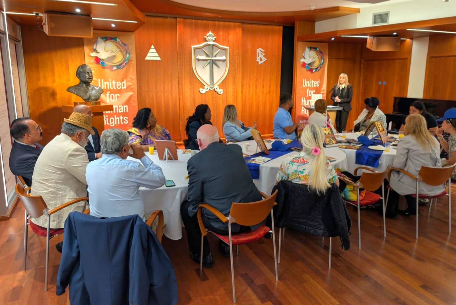 Participants seated around tables during the International Day of Peace round-table gathering in London.