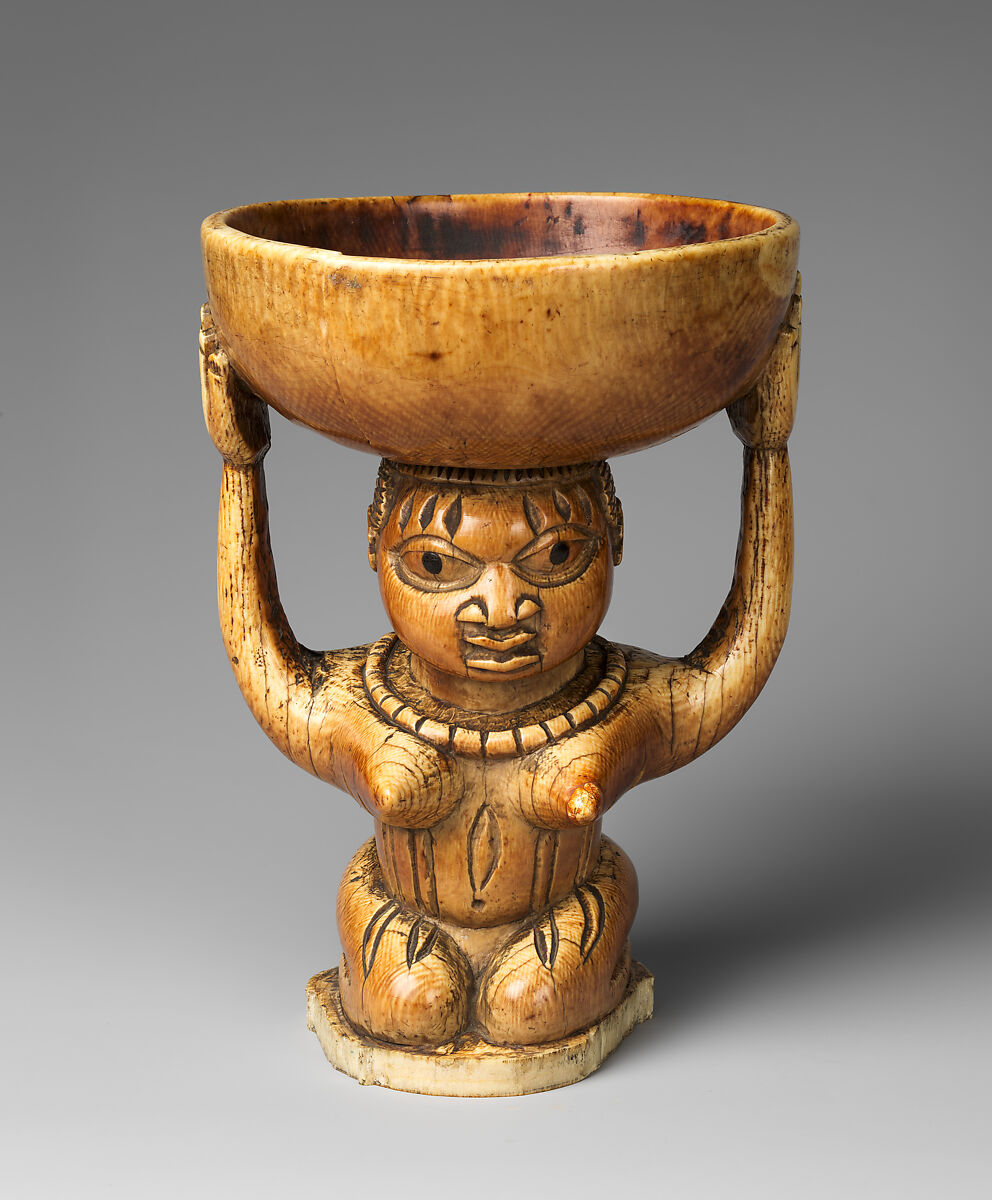 Ivory àgéré Ifá from Owo showing a kneeling woman supporting a bowl, dated to the seventeenth to nineteenth century.