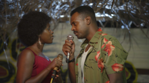 Chisom Agoawuike and Adam Garba holding microphones in a scene from To Adaego With Love