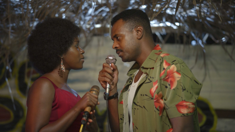Chisom Agoawuike and Adam Garba holding microphones in a scene from To Adaego With Love