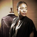 Archive portrait of fashion designer Deola Sagoe beside a dress form