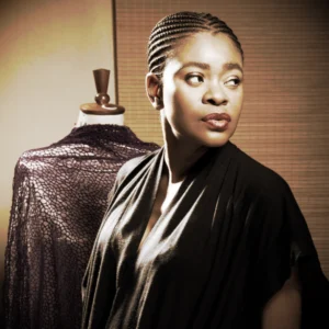 Archive portrait of fashion designer Deola Sagoe beside a dress form