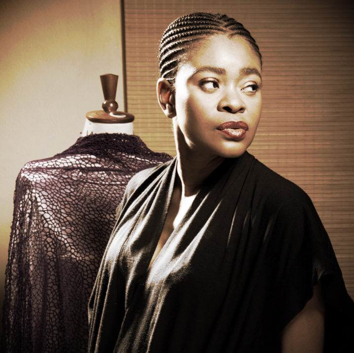Archive portrait of fashion designer Deola Sagoe beside a dress form