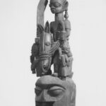 Black-and-white archive photograph of a Yoruba Ẹpa headdress with a mounted figure and attendants, Brooklyn Museum 70.107.13.