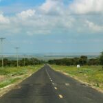 A paved highway running through the Kenyan landscape