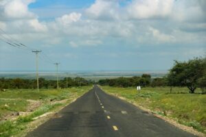 A paved highway running through the Kenyan landscape