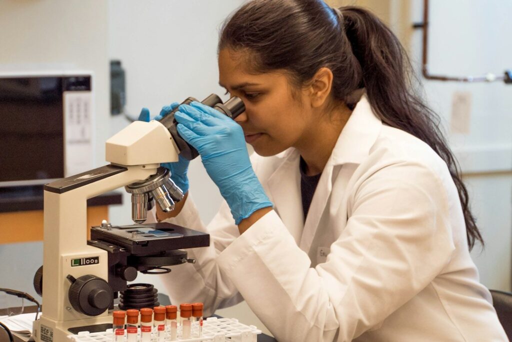 Laboratory scientist examining samples through a microscope