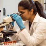 Laboratory scientist examining samples through a microscope
