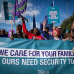 Migrant care workers holding We Care for Your Families banner at the Liverpool demonstration
