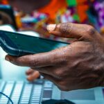 Nigerian man using a smartphone, illustrating Lagos cybersecurity awareness and online fraud prevention