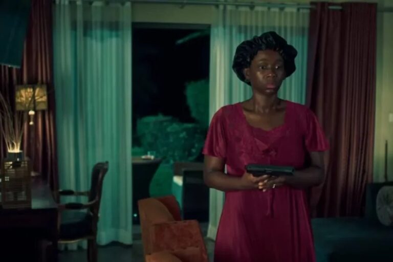 A woman in a burgundy dress holds a handgun in an interior scene from Phoenix Fury