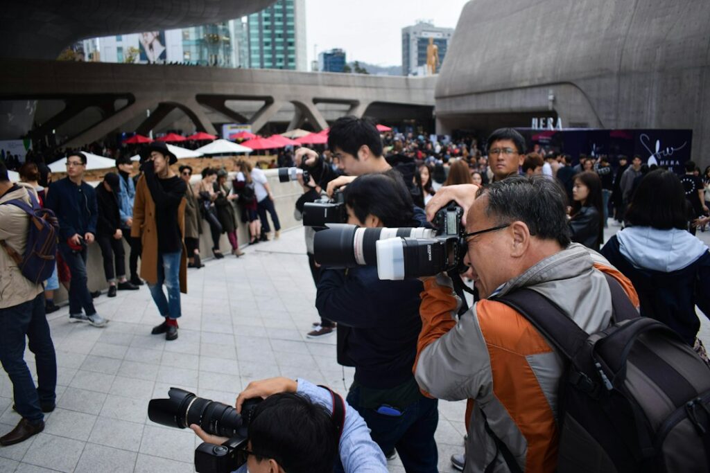 Group of press photographers holding cameras at a public event