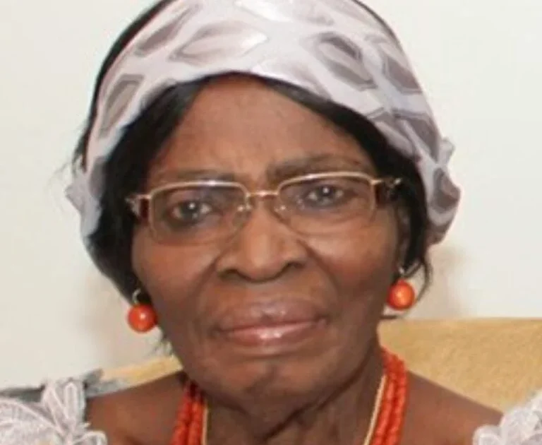 Professor Kamene Okonjo wearing glasses, a patterned headwrap and coral jewellery.