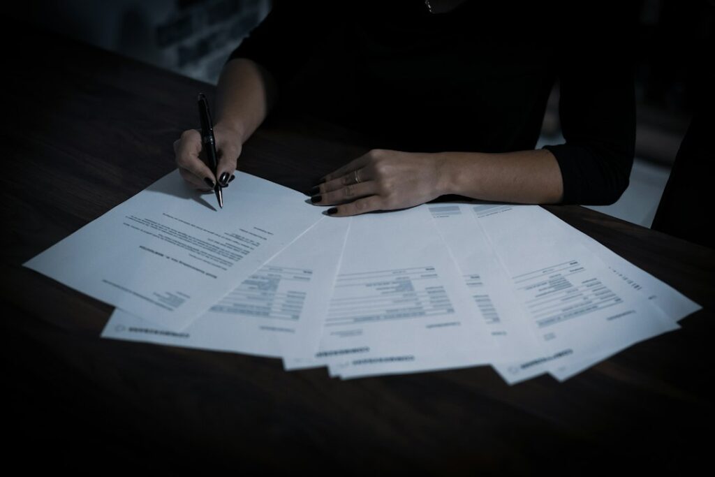 A person signing retirement paperwork with a pen