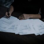 A person signing retirement paperwork with a pen