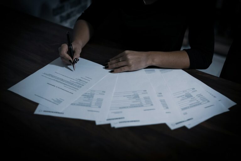 A person signing retirement paperwork with a pen