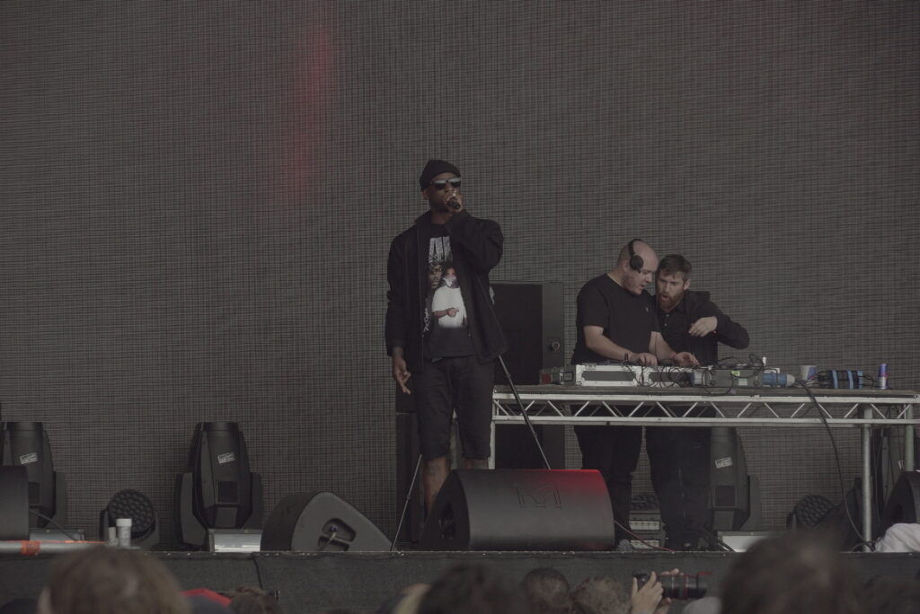 Skepta holding a microphone on stage at Field Day in London on 11 June 2016