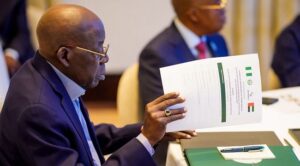 President Bola Tinubu holding a document during a meeting in an archive photograph