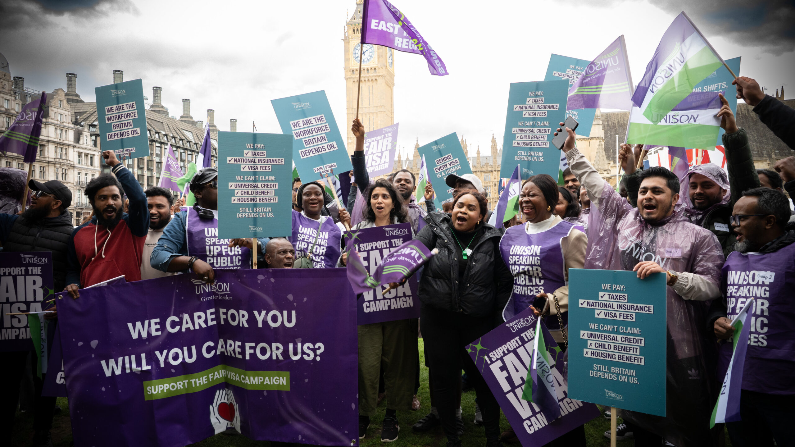 Care workers holding Fair Visas campaign signs in Westminster