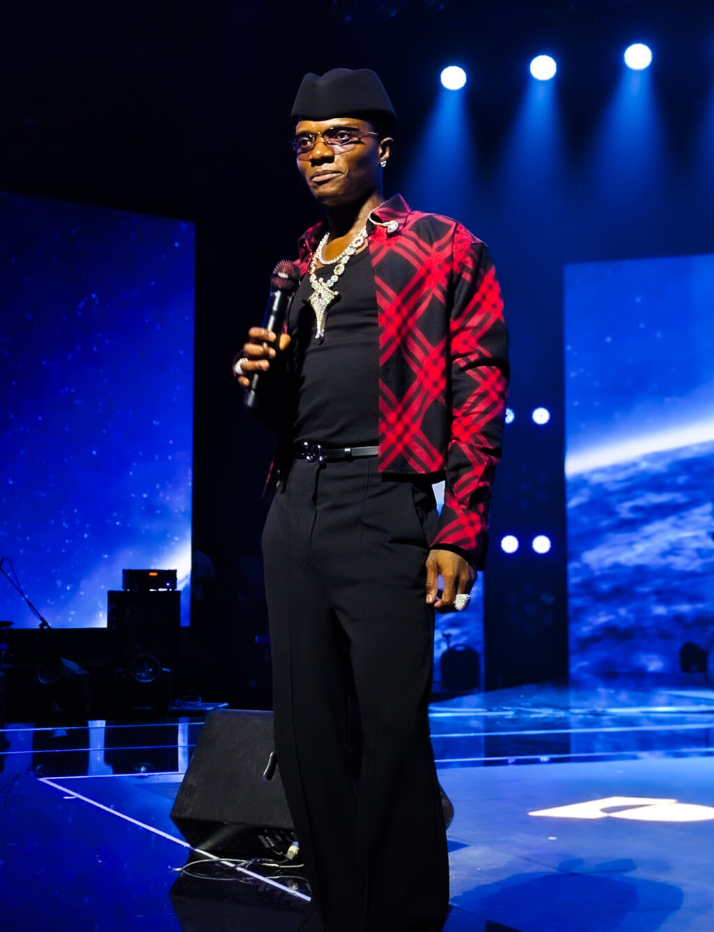 Wizkid holding a microphone during his Canex performance in Algiers in September 2025