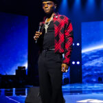 Wizkid holding a microphone during his Canex performance in Algiers in September 2025
